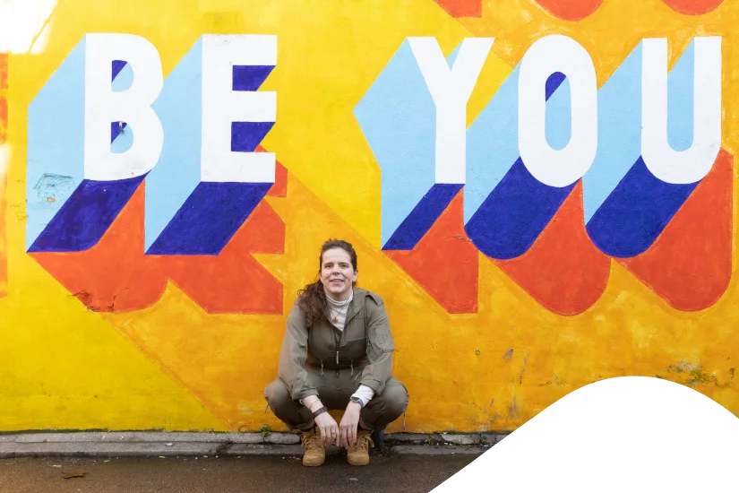 Anaïs Bresle in front of a colourful “Be You” mural